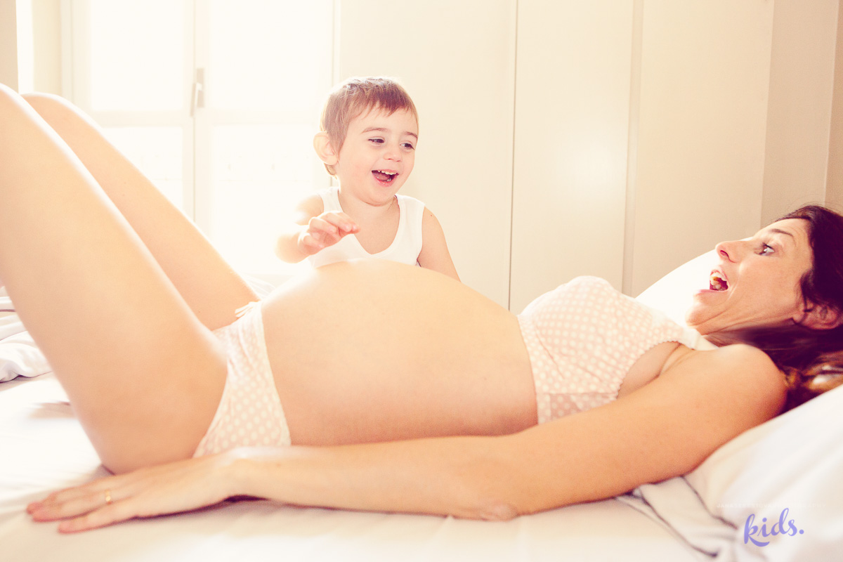 bimbo che ride sulla pancia di mamma incinta