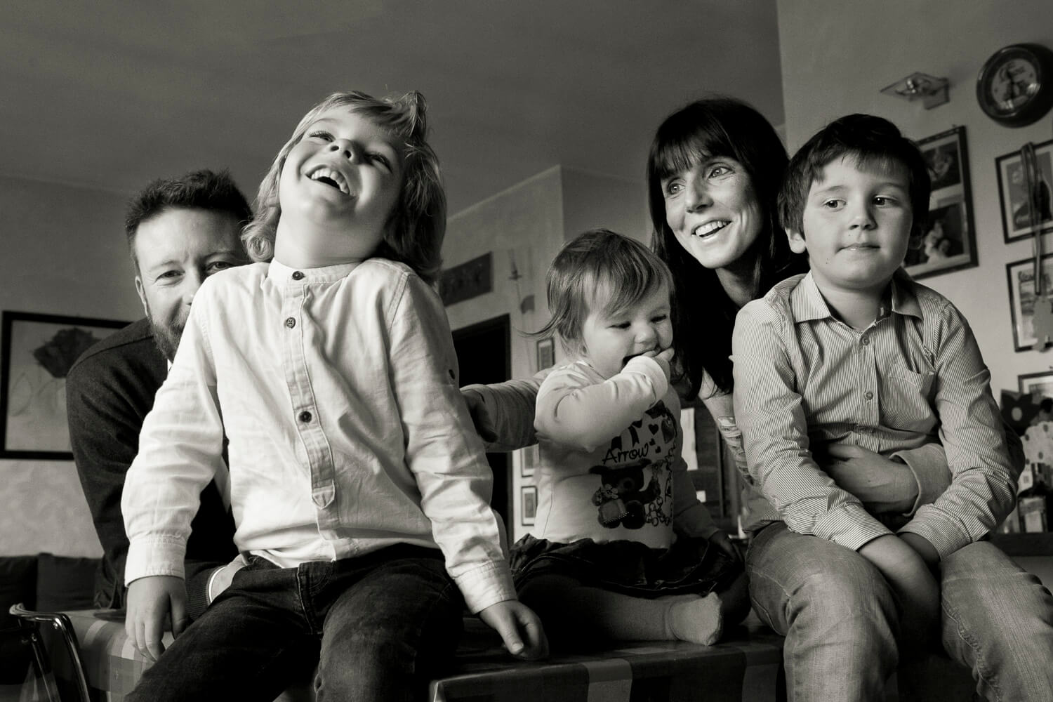 ritratto disinvolto di famiglia con tre bambini sul tavolo di cucina