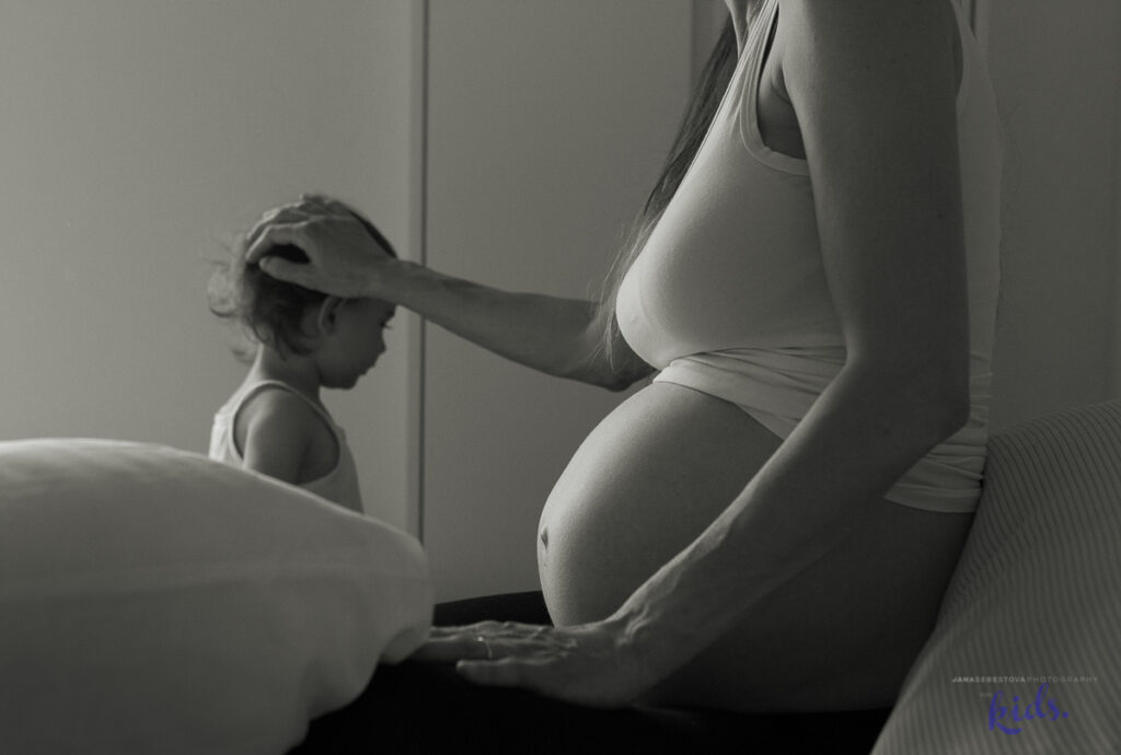 mamma incinta accarezza sulla testa figlia piu grande, pregnant mother caresses older kid