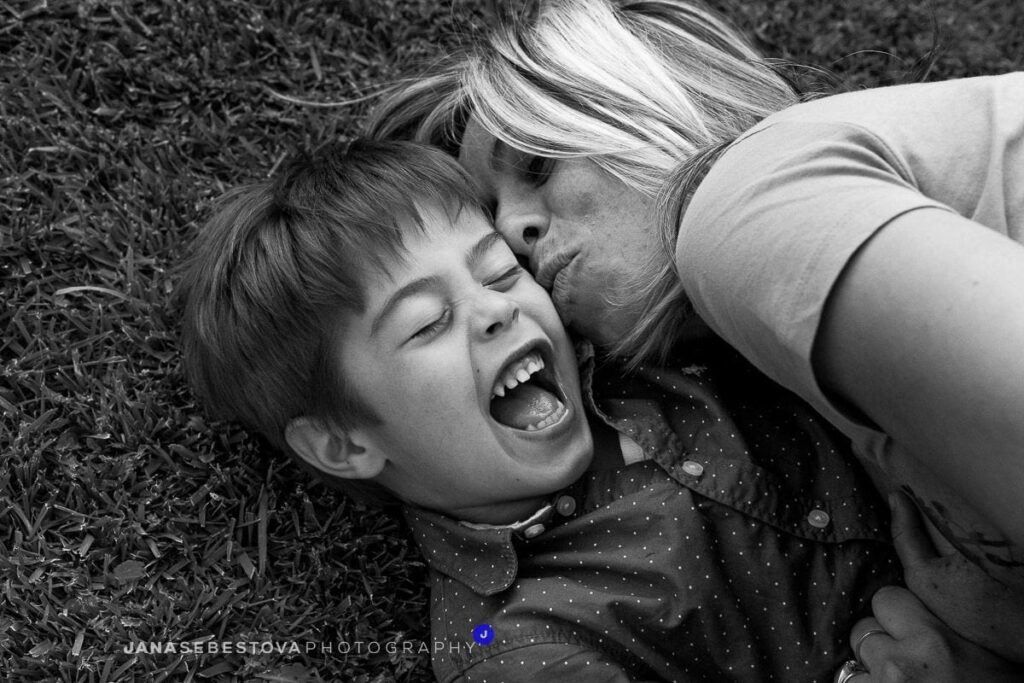 mamma con figlio ridono su erba