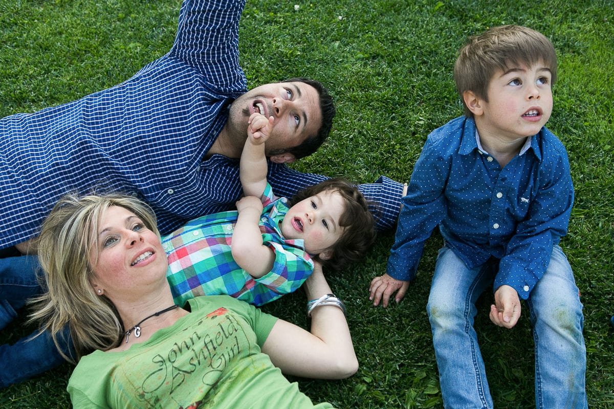 family with two boys playing on grass