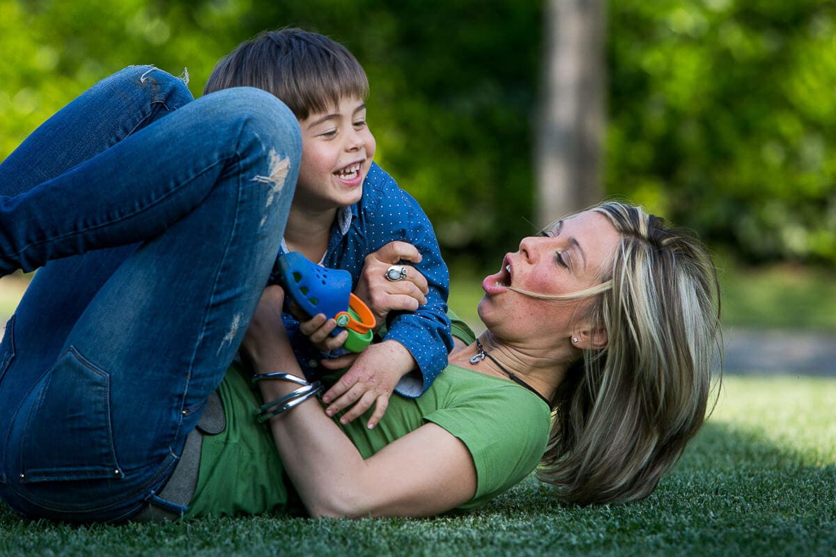 mum is shouting while playing with little son on grass