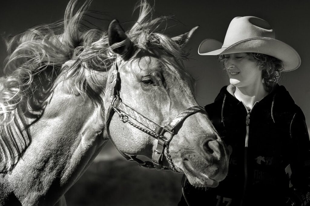 portrait of girl with her horse in windy weather