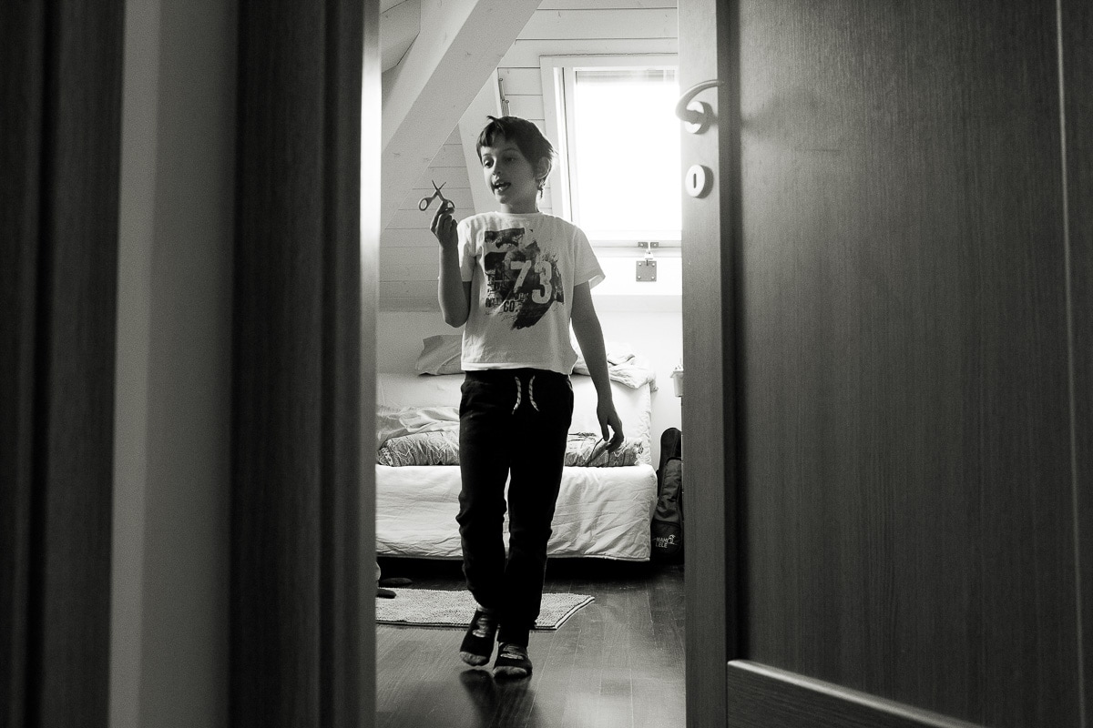 boy with a toy in hand in the door of his room