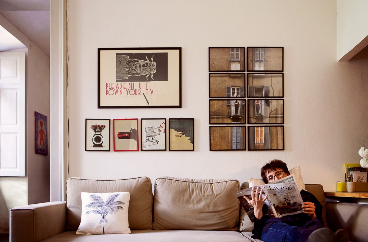 architetto angela tomasello legge giornale seduta su sofa a casa sua