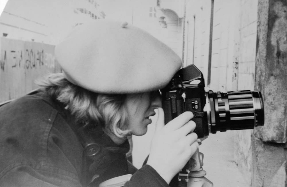 young woman in basque hat looking at viewfinder of pentax 6x7
