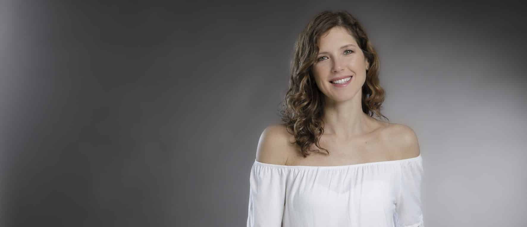 foto ritratto professionale di giovane donna con camicia bianca a spalle scoperte