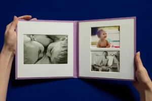 An open photo album displaying black-and-white and color images of babies.