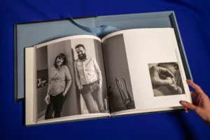 An open photo book revealing a black-and-white image of a couple standing together. An open photo book revealing a black-and-white image of a couple standing together.