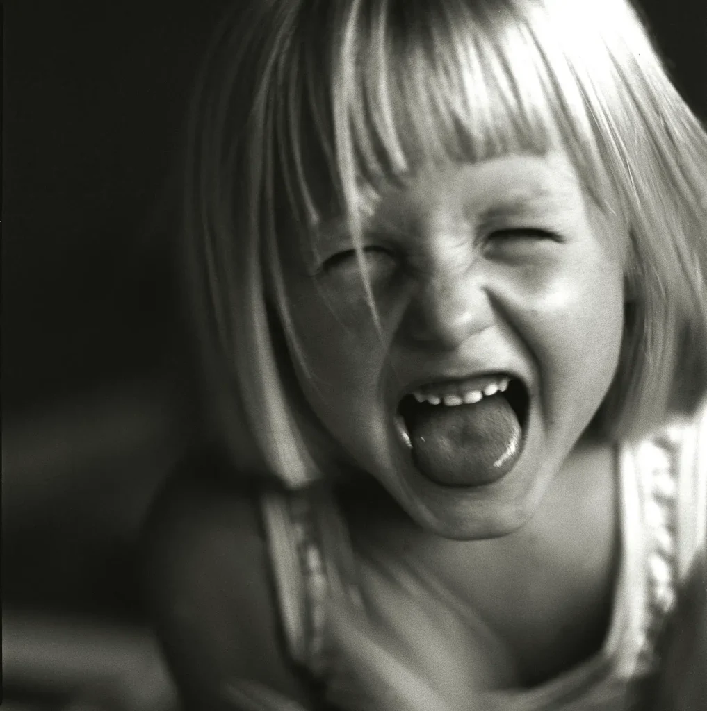 screaming girl with close eyes and blond french bob hairstyle