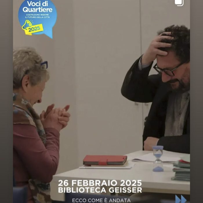Una donna e un uomo siedono a un tavolo e parlano e ridono. L'uomo si tocca la testa sorridendo. Il testo sopra l'immagine recita: 26 febbraio 2025 Biblioteca Geisser Ecco come è andata.